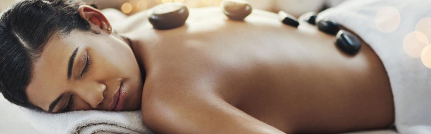 say-goodbye-to-those-sore-muscles-shot-of-young-woman-getting-hot-stone-massage-at-spa